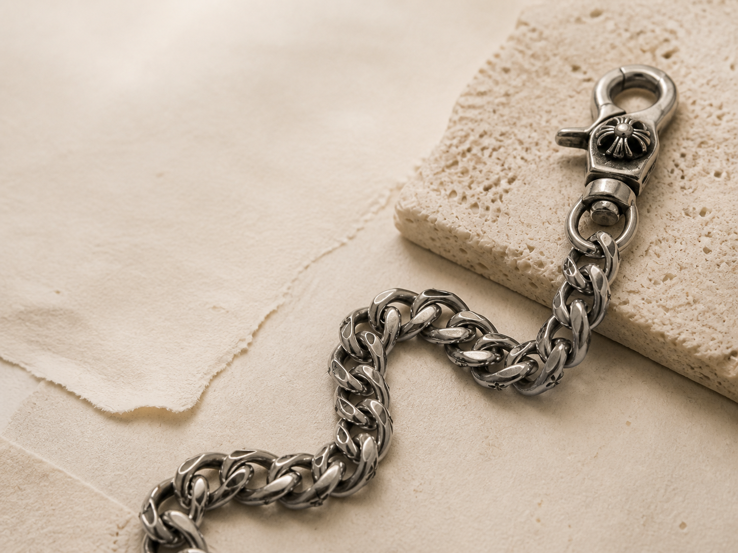 Silver gothic wallet chain on warm stone